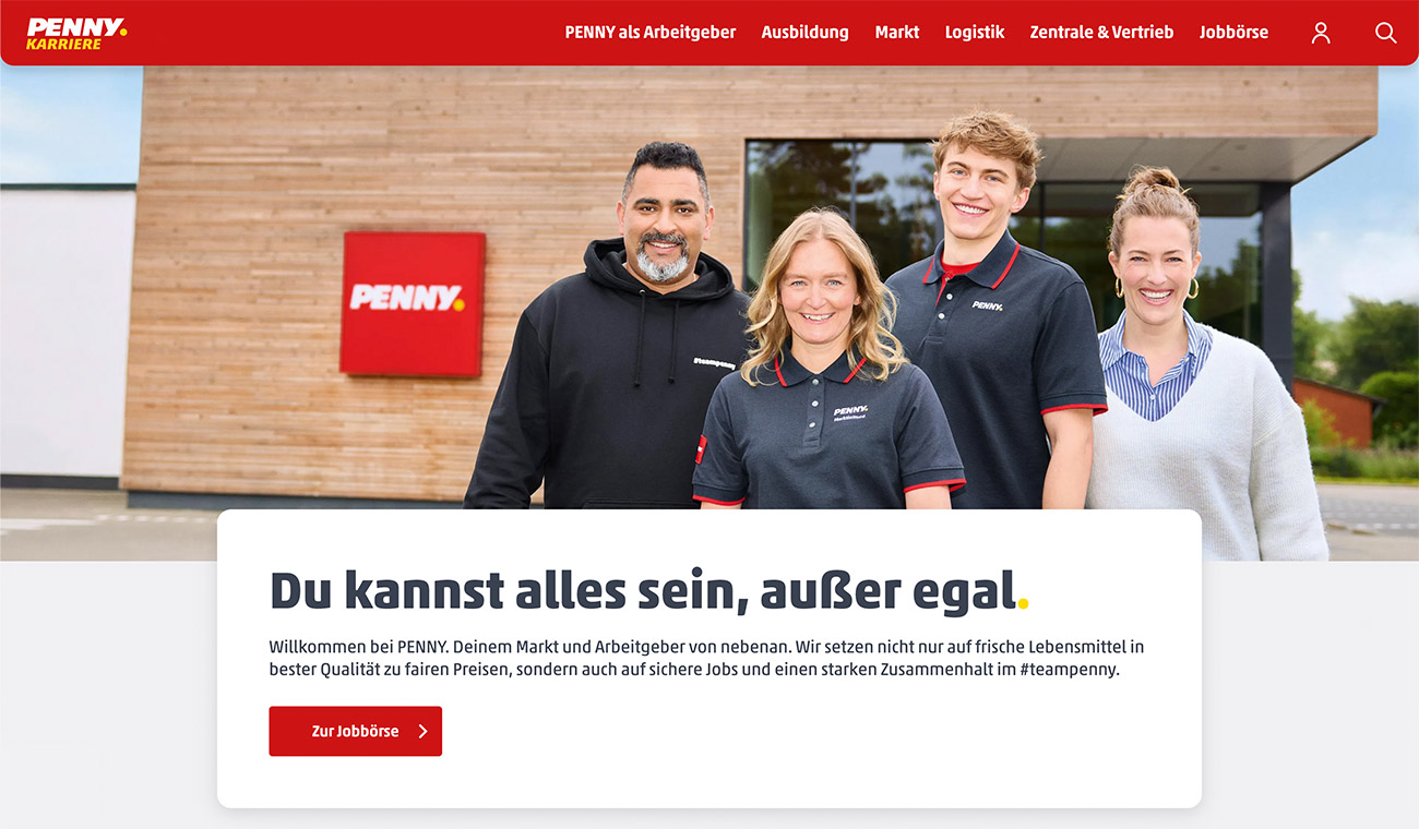 Vier Mitarbeitende stehen vor einem Gebäude mit PENNY-Schild; darunter ein Textfeld mit dem Slogan „Du kannst alles sein, außer egal.“ und Button „Zur Jobbörse“.